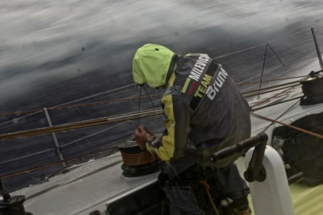 Rokas Milevicius trims the sail while the team sail through a heavy rain cloud - Volvo Ocean Race 2014-15 © Stefan Coppers/Team Brunel